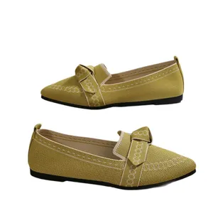 Elegantes zapatos planos de punto con punta fina en amarillo mostaza y lazo decorativo