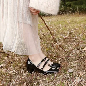 Gros plan de chaussures Mary Jane en cuir verni noir avec doubles brides et bout carré.