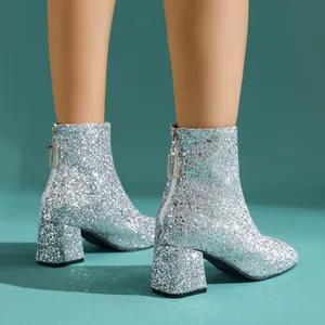 Detalle de los botines plateados con purpurina y un tacón alto ancho muy moderno
