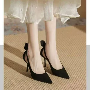 Detailed view of elegant black pointed-toe high heels with a stylish bow on the heel