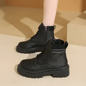 Detalle de botas de plataforma negras con cordones delanteros y cremallera lateral.