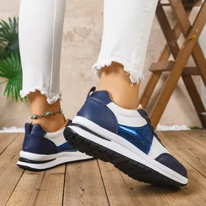 Λεπτομέρεια από μπλε και λευκά γυναικεία sneakers πλατφόρμα με χοντρή λευκή σόλα