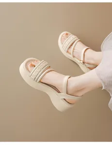 Vista detallada de sandalias beige con plataforma y correas texturizadas en pies
