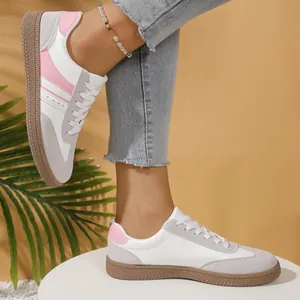 Close-up of stylish retro white and pink German Army Trainers worn by a model in a studio