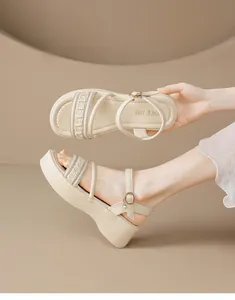 Primer plano de sandalias de plataforma beige con correas de volantes y hebilla