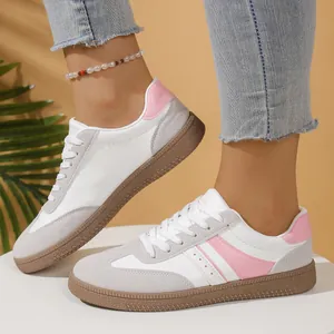 Close-up detail of retro women's German army trainers in pink and white leather