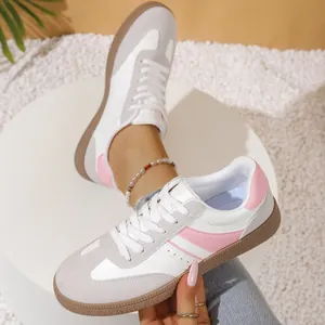 Macro detail of retro style white and pink German Army Trainers for women in a casual setting