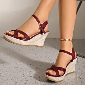 Detail shot of burgundy criss-cross wedge sandals with elegant straw-woven sole