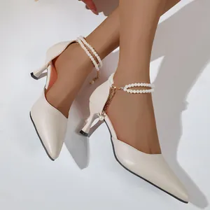 Elegant beige pointed-toe high heels featuring decorative pearl ankle straps