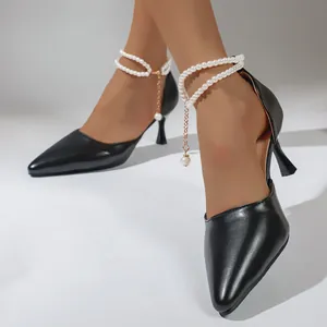 Elegant black pointed-toe stiletto pumps with decorative pearl ankle chain straps.
