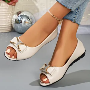 Detailed view of elegant beige peep toe flat shoes featuring a stylish rhinestone bow