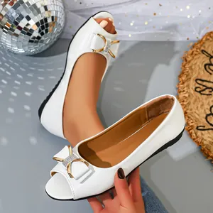 Detailed macro view of elegant white peep-toe flat shoes with rhinestone bow decoration