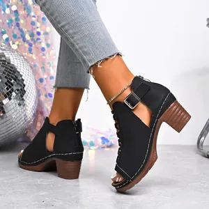 Close-up of black peep-toe sandals with chunky wood-effect heels and side buckle.