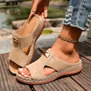 Gros plan de sandales compensées kaki pour femmes avec découpes latérales et boucles en métal.