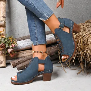 Detail view of blue peep-toe sandals with chunky heels and buckle straps on a model