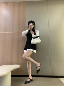 Close-up view of elegant black mesh pointed-toe mules with block heels on a model