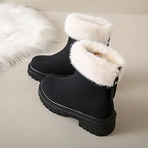Détail de bottes d'hiver noires avec bordure en fausse fourrure blanche et fermeture éclair