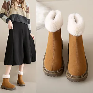 Vue détaillée de bottes de neige en daim marron avec garniture en fausse fourrure blanche