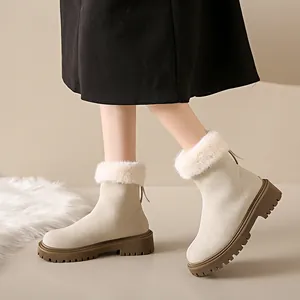 Vue détaillée de bottes de neige en daim beige avec garniture en fausse fourrure.