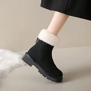 Détail d'une botte de neige noire avec col en fausse fourrure blanche et semelle