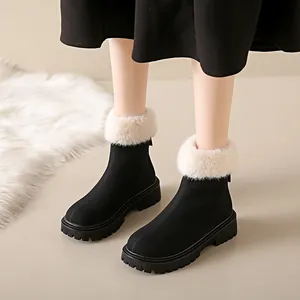 Détail de bottes de neige d'hiver noires avec garniture en fausse fourrure blanche.
