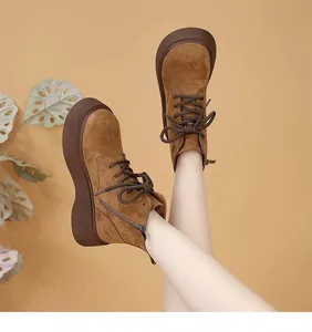 Creative detail shot of brown suede platform Martin boots featuring a side zipper