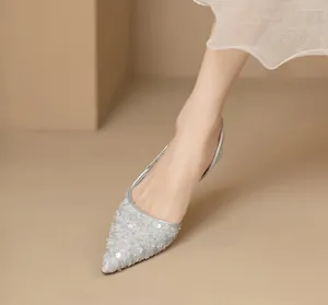 Elegante spitze Abendschuhe mit silbernen Pailletten als Detailaufnahme am Modell