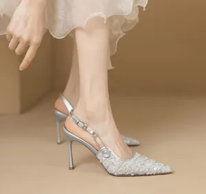Detail von silbernen spitzen High Heels mit Pailletten und Metallschnalle.