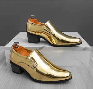 Luxury shiny gold men's dress shoes with cuban heel on a marble display stand.