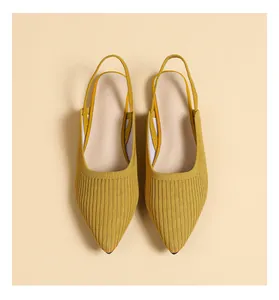 Detailed top view of mustard yellow knitted pointed-toe slingback flats with ribbed texture