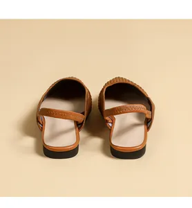 Rear view detail of brown knitted pointed toe slingback flats with elastic strap.