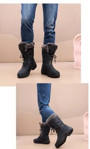 Detalle de botas de nieve negras con cordones, forro de pelo grueso y diseño alto.