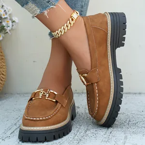 Κοντινό πλάνο καφέ καστόρινα loafers με πλατφόρμα, χρυσή αγκράφα και χοντρή σόλα για γυναίκες