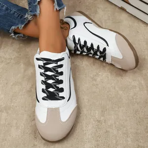 Vue détaillée de baskets décontractées blanches et beige avec lacets tissés noirs