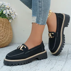Λεπτομέρεια μαύρα loafers πλατφόρμα με χρυσή αγκράφα και λευκές ραφές για γυναίκες