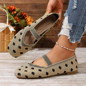 Detalle de bailarinas Mary Jane de punto beige con lunares y tira elástica cruzada.
