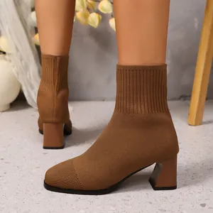 Nahaufnahme von braunen Strick-Stiefeletten mit Blockabsatz und eleganter Textur.
