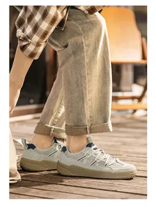 Side view of men's retro casual sneakers on a wooden deck during warm sunset light
