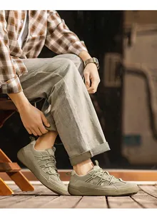 Detailed side view of olive green retro German Army Trainer shoes worn with casual trousers