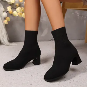 Detail von eleganten schwarzen Strick-Socken-Boots mit dickem hohen Absatz für Damen