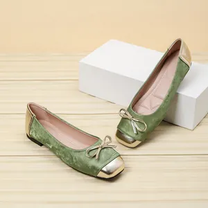Close-up of green velvet ballet flats with gold square toe and bow detail