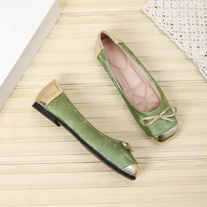 Detailed view of sage green square toe ballet flats with gold bow and metallic accents