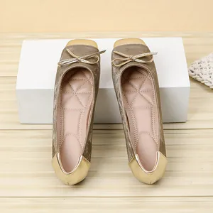 Macro view of champagne velvet ballet flats with gold square toe and delicate bow detail.