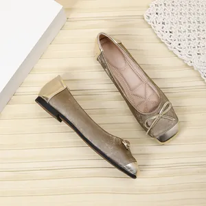 Close-up of elegant gold metallic square-toe ballet flats featuring delicate bow decoration