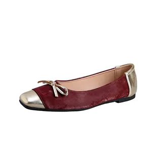 Detail of burgundy velvet flat shoe with metallic gold square toe and bow