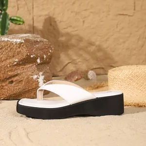 Detailed view of white leather platform flip-flops with a trendy square toe design.