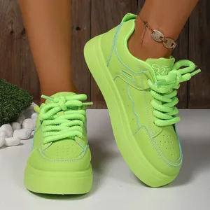 Close-up detail of neon green platform sneakers with thick laces and chunky sole.