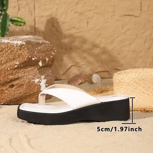 Detailed side view of white platform flip flop showing 5cm heel height on a sandy beach