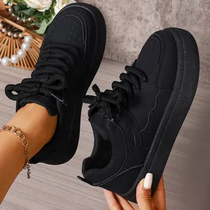 Detailed view of women's black platform chunky bread sneakers with thick laces in a cozy setting