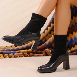 Detailansicht schwarzer Modestiefel mit Blockabsatz und elastischem Schaft am Modell.